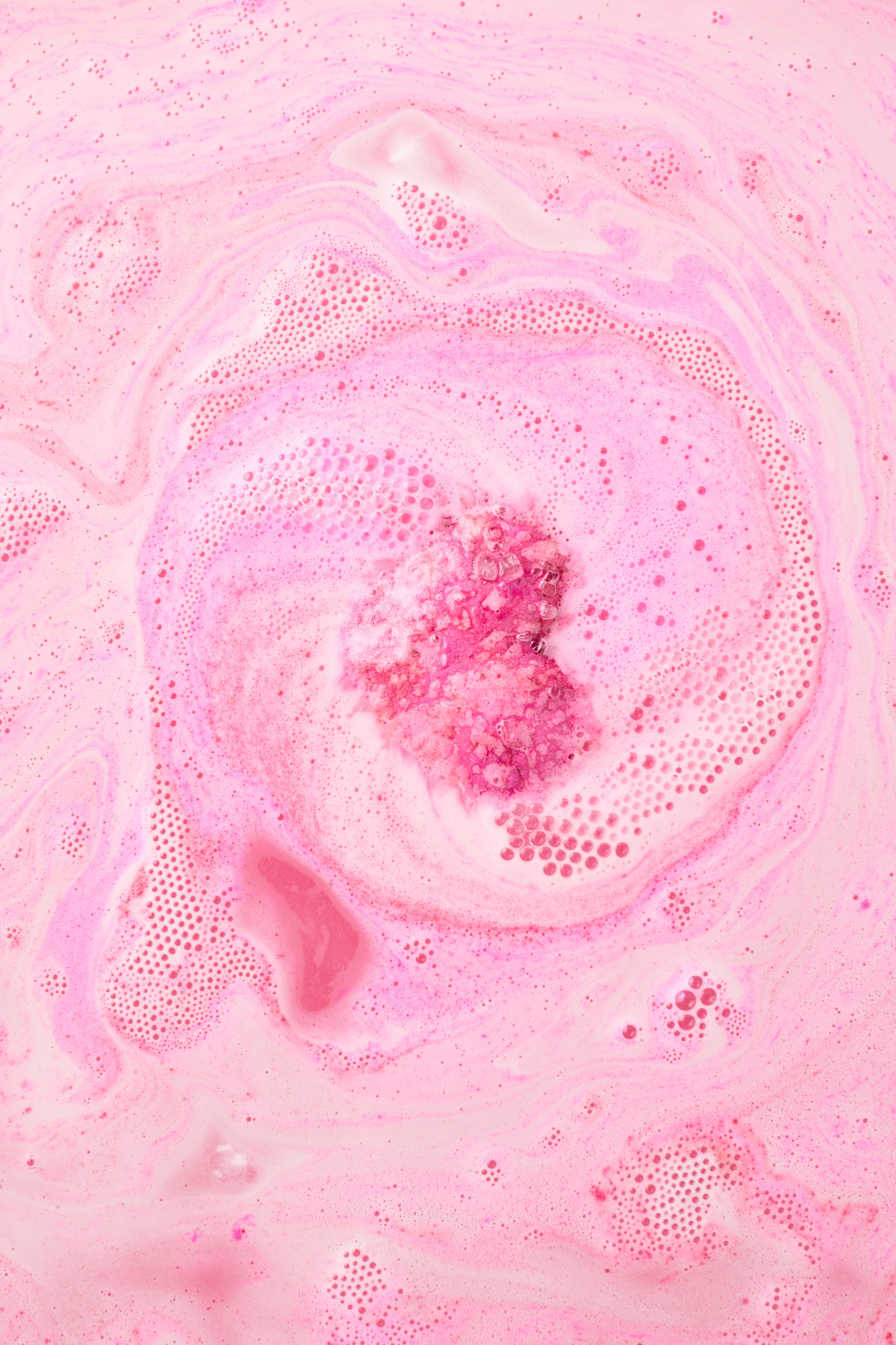 Pink bath bomb in a bath