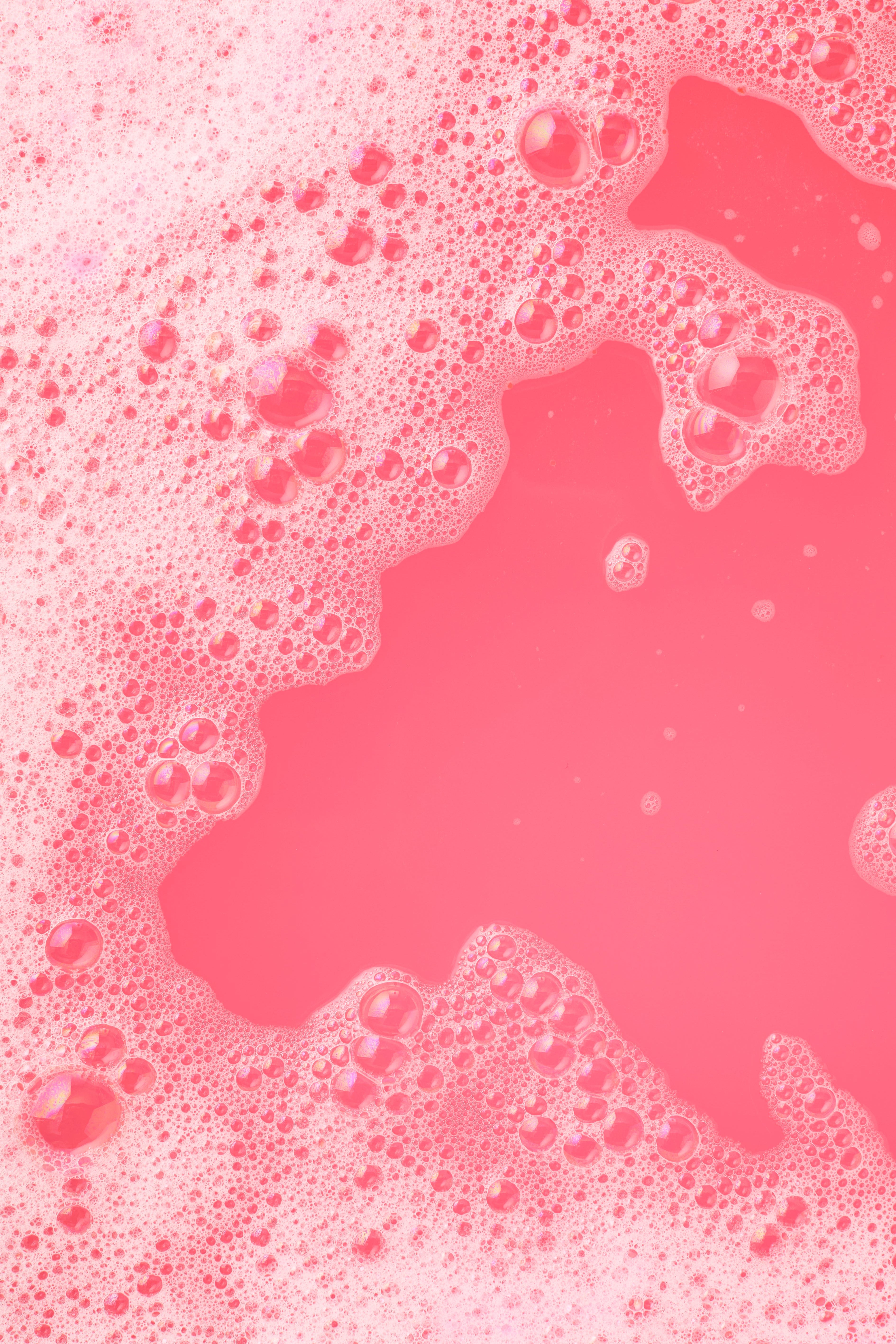 Pink liquid with bubbles on a pink background
