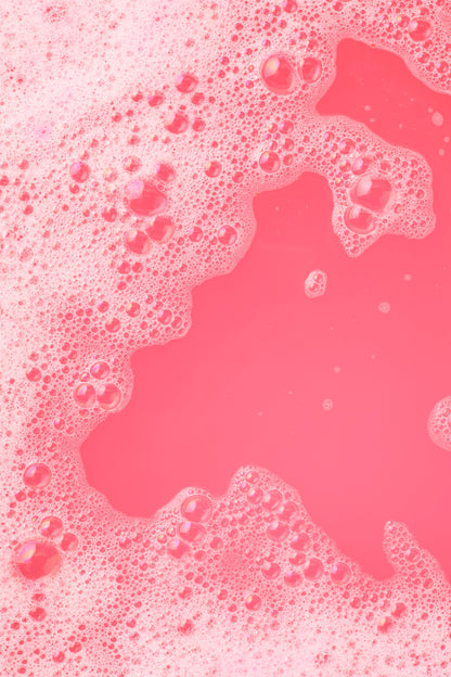 Pink liquid with bubbles on a pink background
