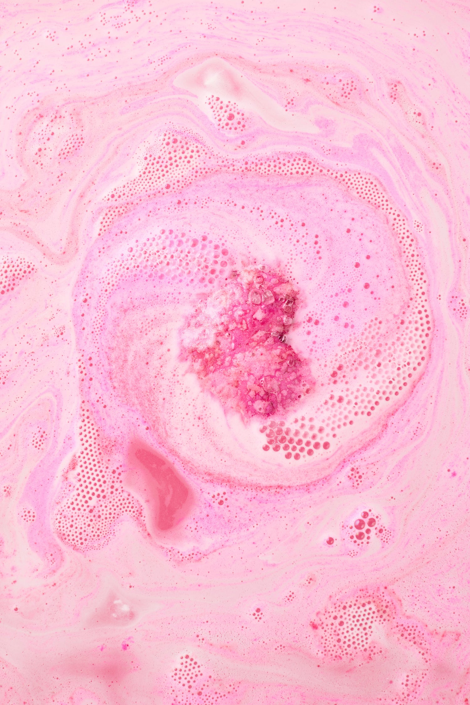 Pink bath bomb in a bath
